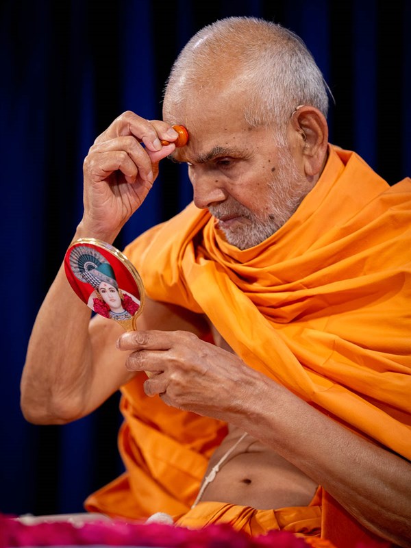 Swamishri applies a chandlo on his forehead 