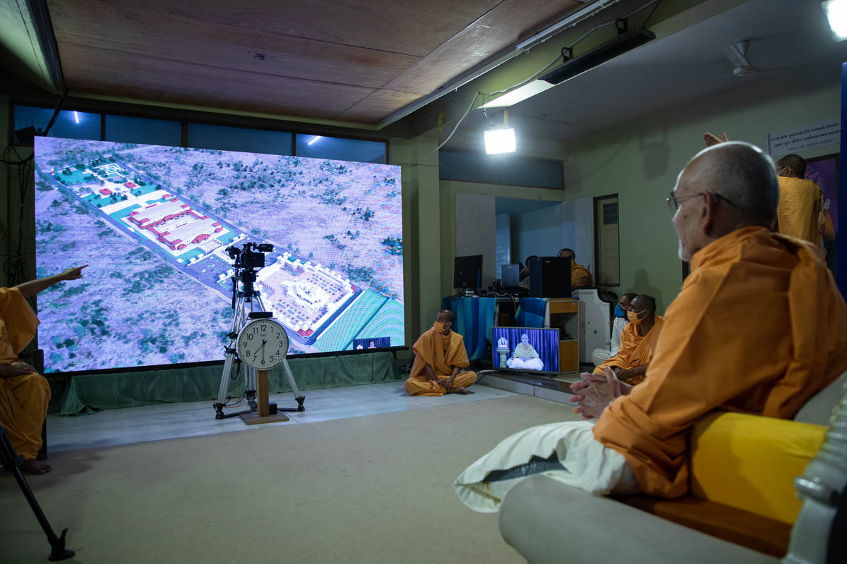 Swamishri observes a site plan of BAPS Shri Swaminarayan Mandir, Sydney, Australia, via video conference