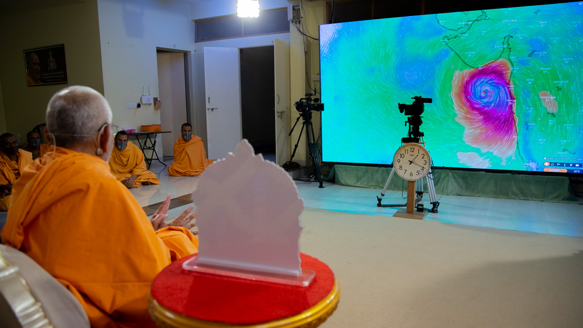 Swamishri watches a live map of the Tauktae Cyclone