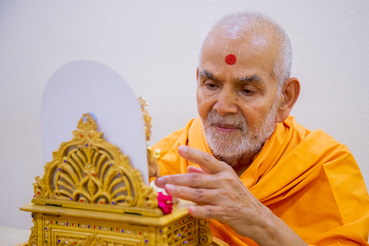Swamishri engaged in darshan of Shri Harikrishna Maharaj and Shri Gunatitanand Swami 