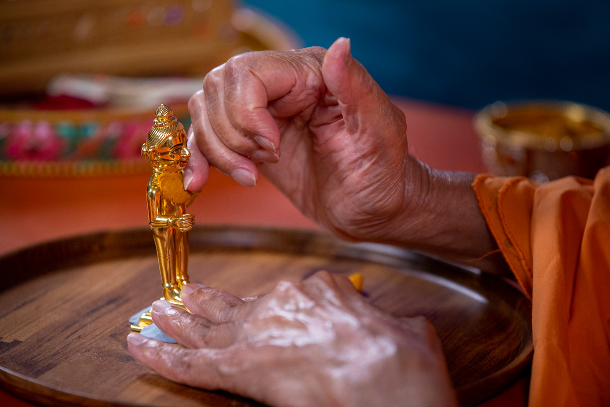 Swamishri adorns Shri Harikrishna Maharaj with chandan garments
