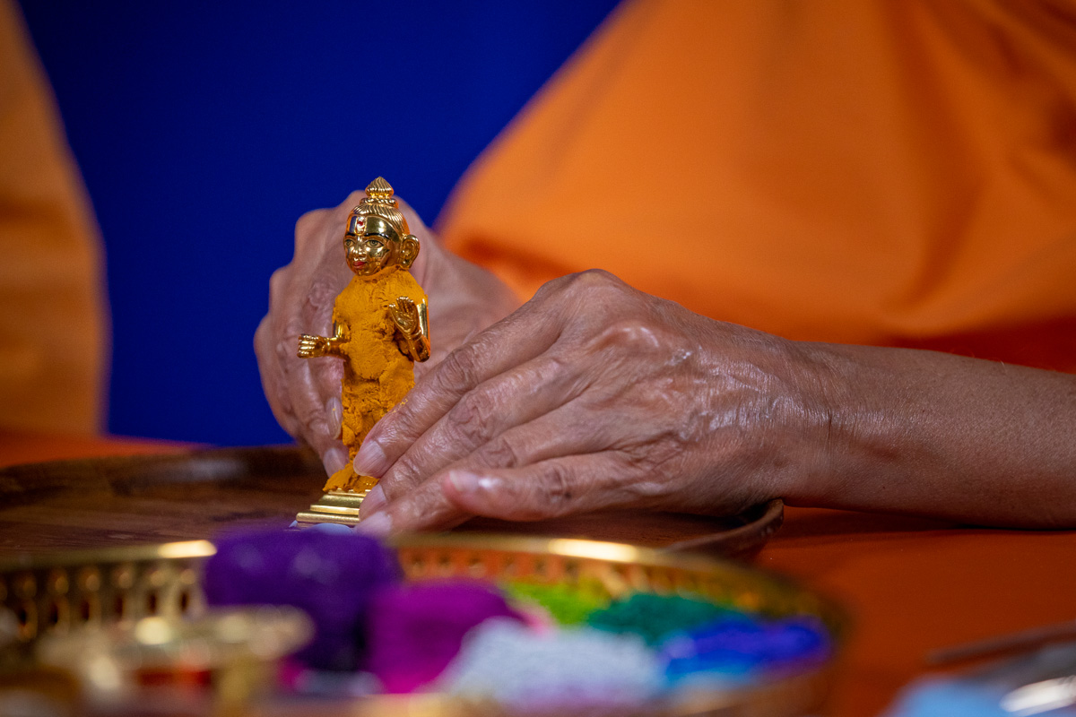 Swamishri adorns Shri Harikrishna Maharaj chandan garments