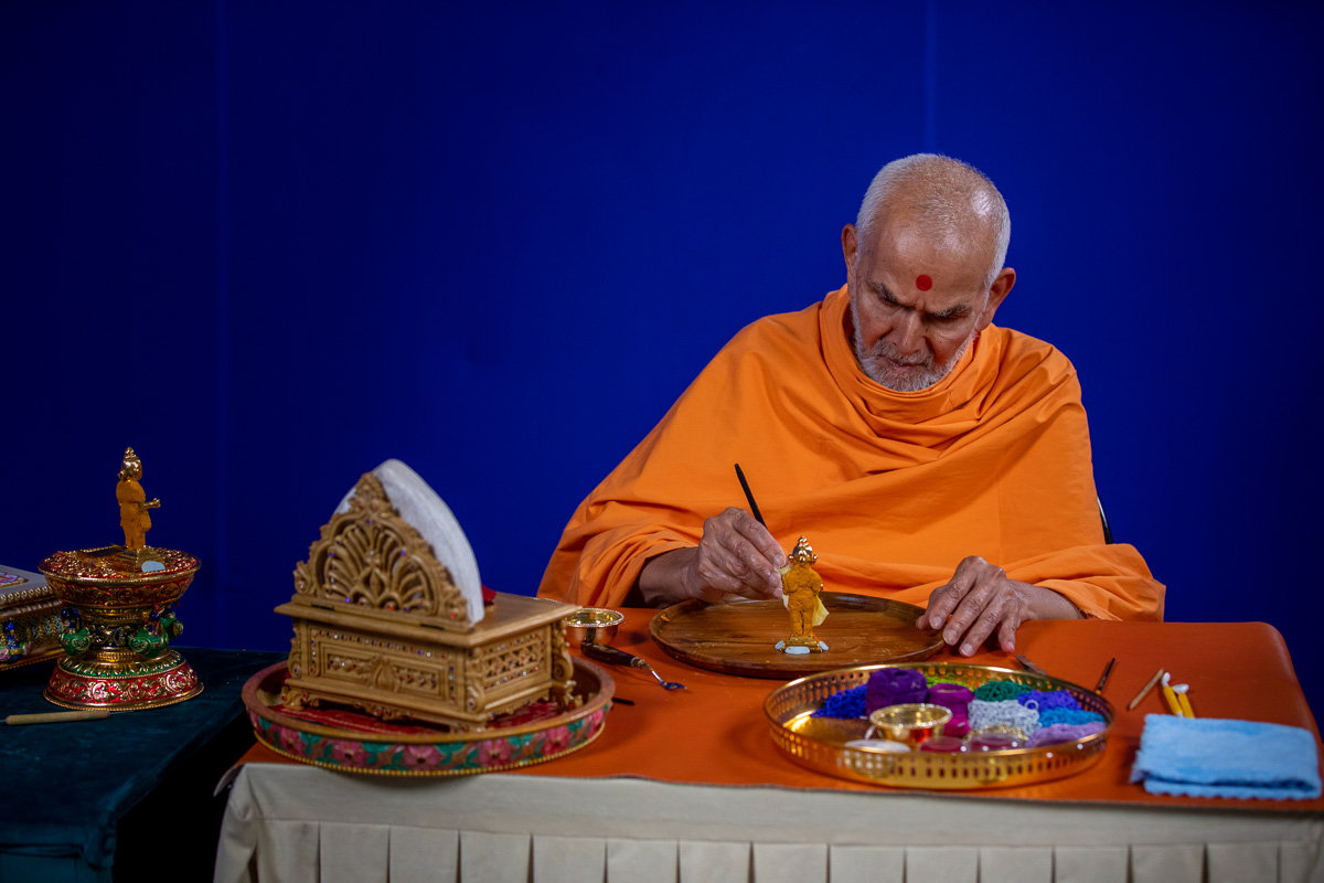 Swamishri adorns Shri Gunatitanand Swami with chandan garments