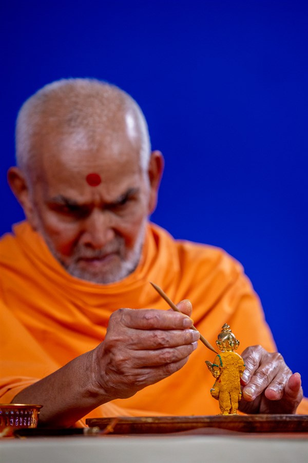 Swamishri adorns Shri Gunatitanand Swami with chandan garments