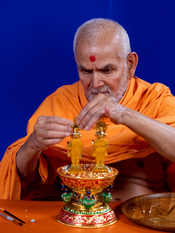 Swamishri adorns Shri Harikrishna Maharaj and Shri Gunatitanand Swami with chandan garments