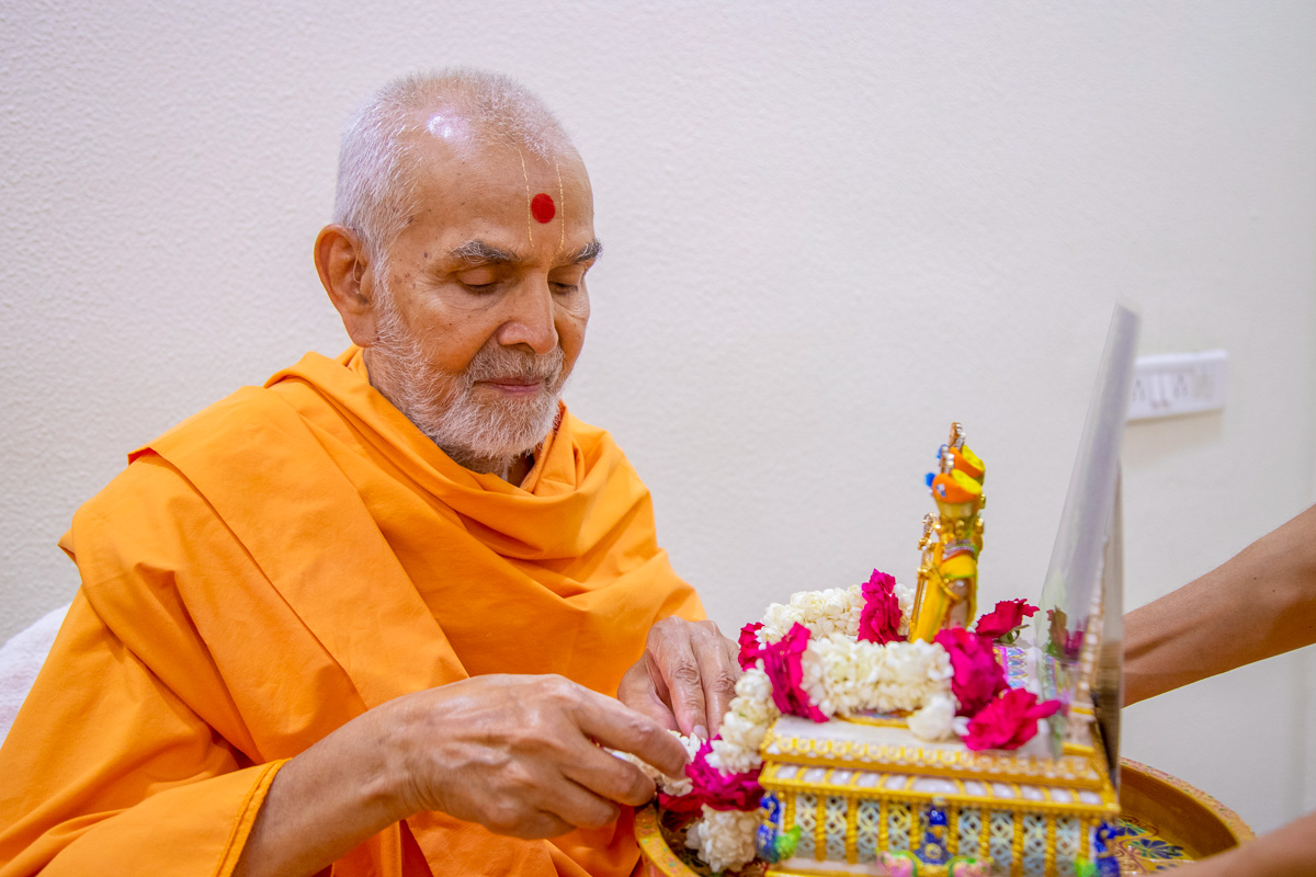 Swamishri honors Shri Harikrishna Maharaj and Shri Gunatitanand Swami with a garland