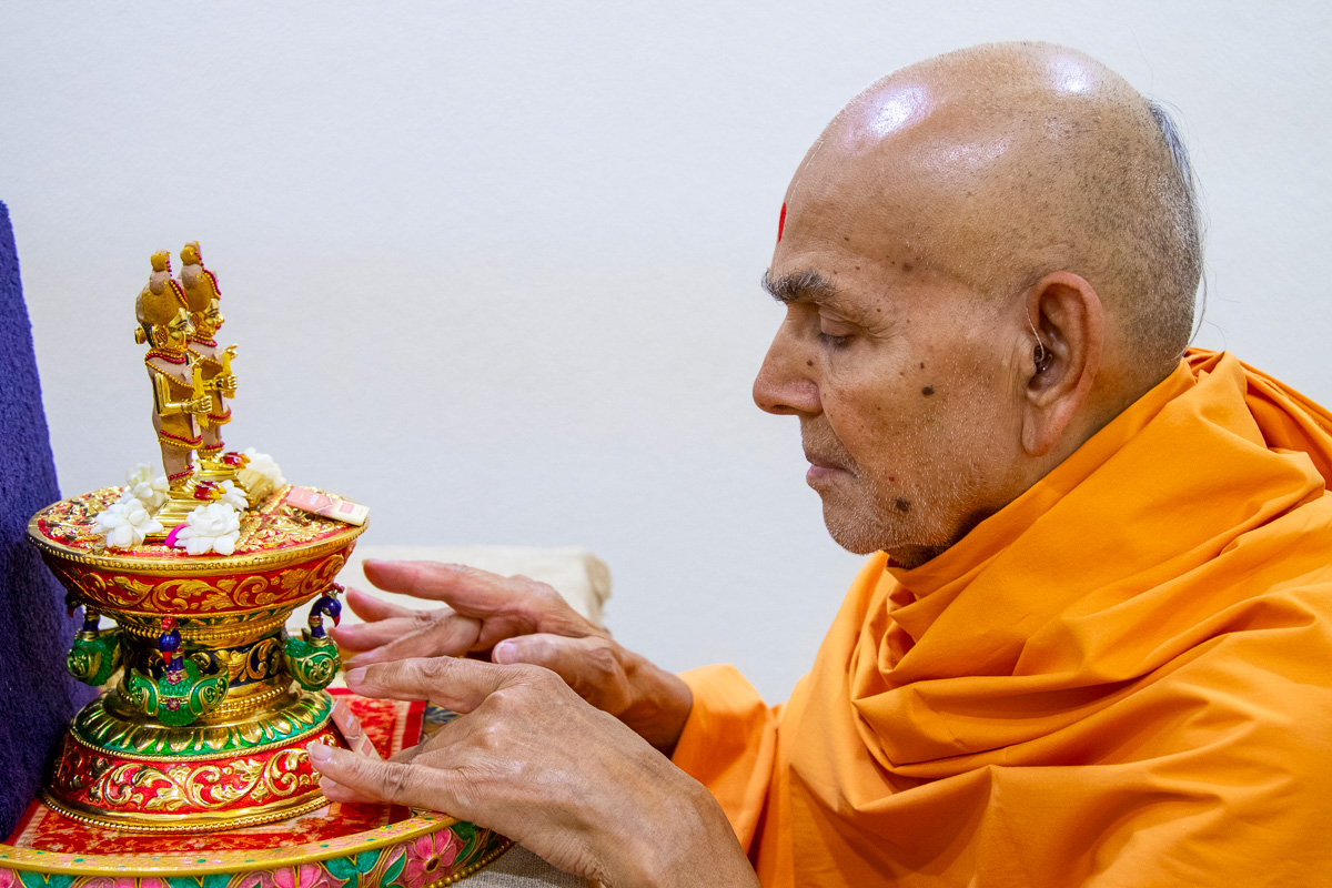 Swamishri adjusts the sinhasan