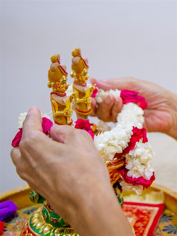 Swamishri honors Shri Harikrishna Maharaj and Shri Gunatitanand Swami with a garland