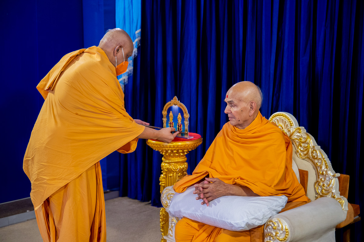 Atmaswarup Swami offers a new video animation publication to Shri Harikrishna Maharaj and Shri Gunatitanand Swami