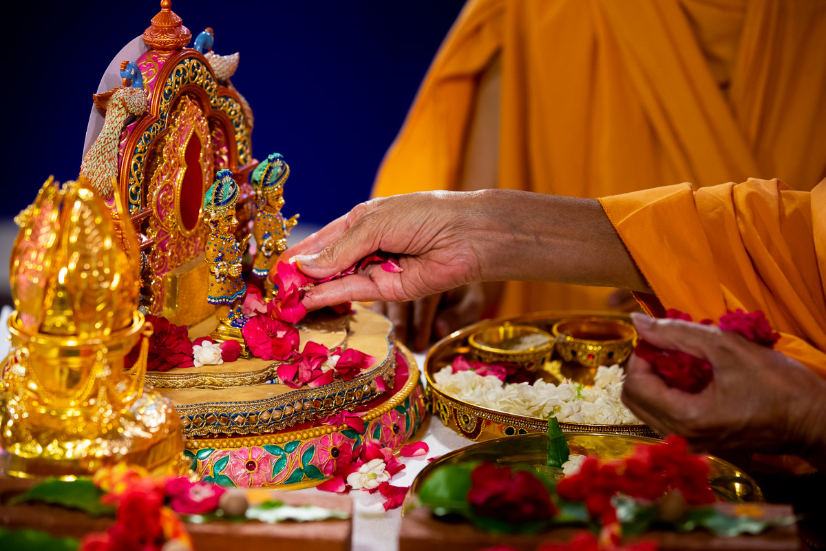 Swamishri offers flower petals to Shri Harikrishna Maharaj and Shri Gunatitanand Swami