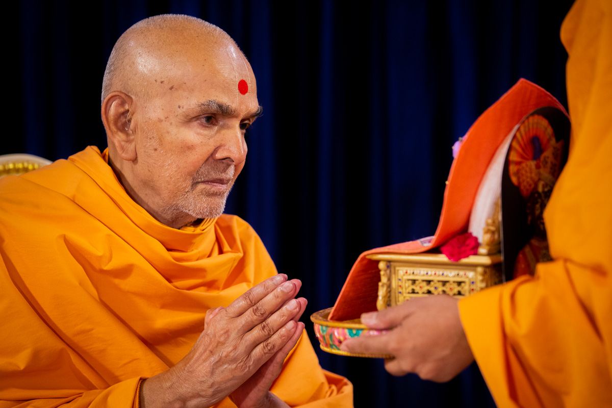 Swamishri engrossed in darshan of Shri Harikrishna Maharaj and Shri Gunatitanand Swami 