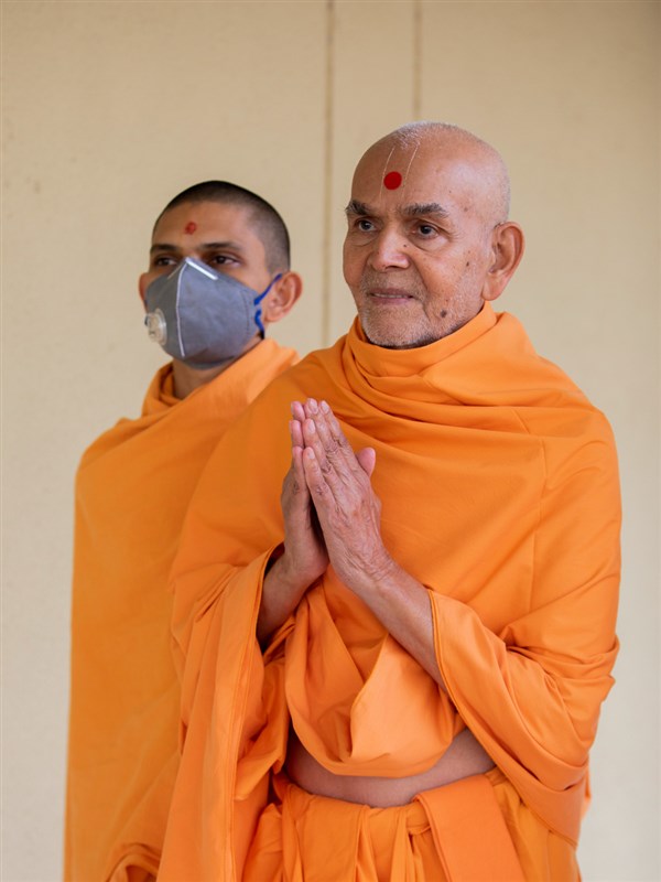 Swamishri greets all with folded hands during his walk in the morning