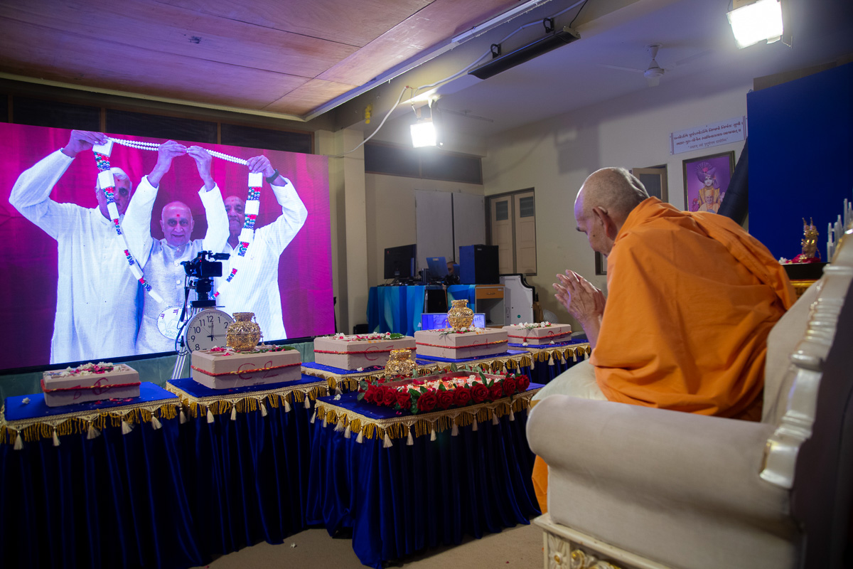 Devotees from Johannesburg Satsang Mandal honor Swamishri with a garland