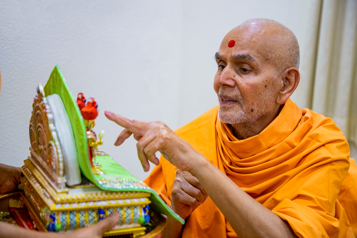 Swamishri engaged in darshan of Shri Harikrishna Maharaj and Shri Gunatitanand Swami