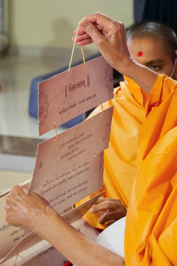 Swamishri observes an invitation card