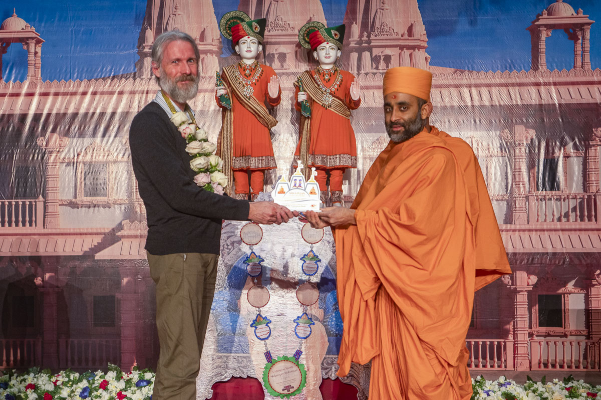 Priyachintan Swami presents a memento to an invited guest