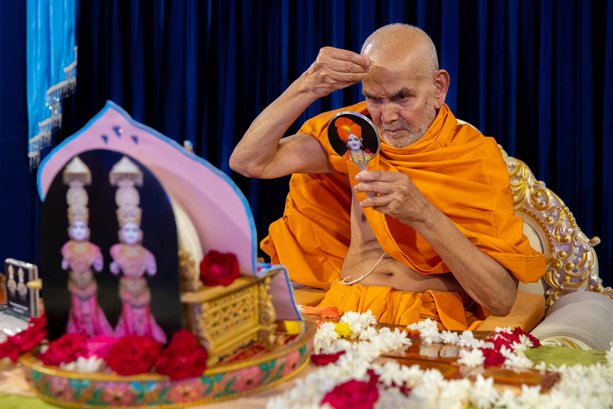 Swamishri applies a tilak on his forehead 