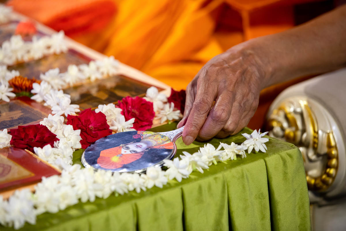 Swamishri adjusts the mirror in his daily puja