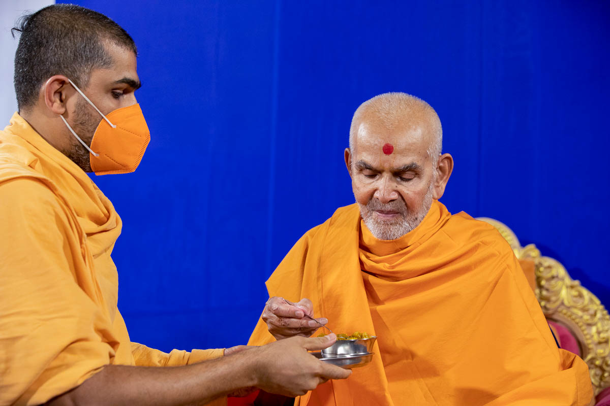 Swamishri partakes shiro from the thal offered to Shri Harikrishna Maharaj and Shri Gunatitanand Swami