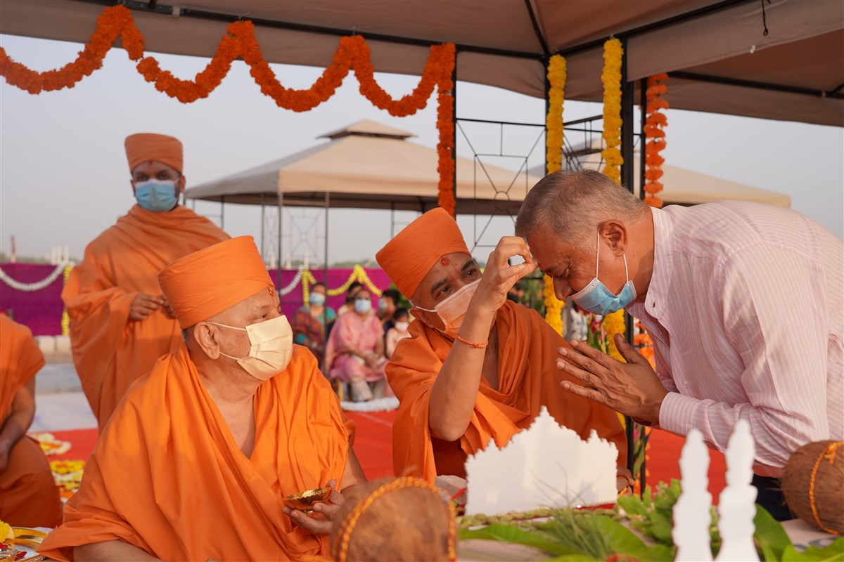 Brahmavihari Swami applies a chandlo to Shri Yogeshbhai Mehta