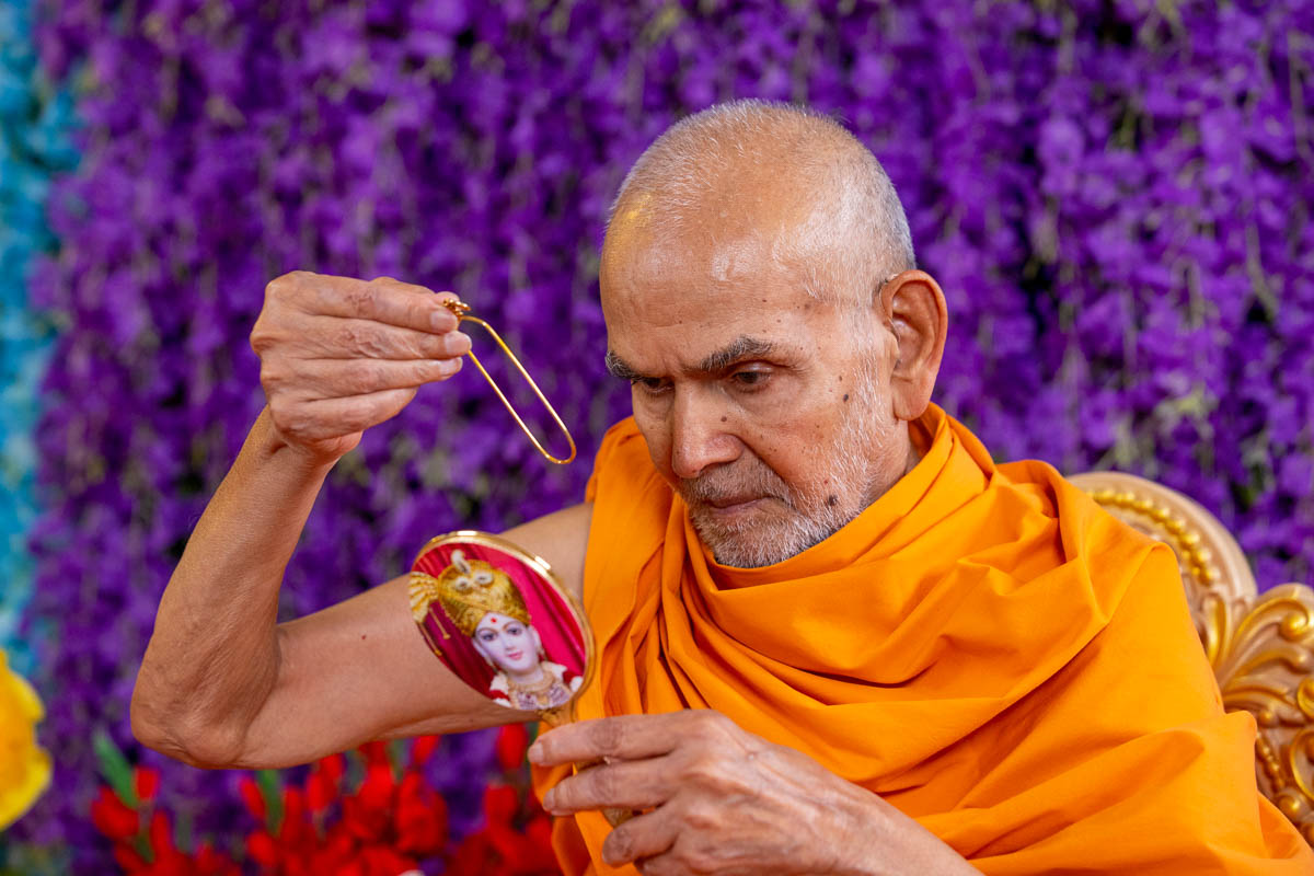 Swamishri applies a tilak on his forehead at the beginning of his daily puja