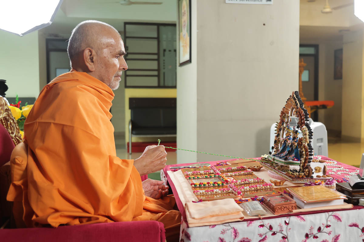 Swamishri swings Shri Harikrishna Maharaj and Shri Gunatitanand Swami on a hindolo