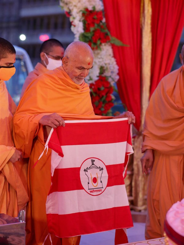 Swamishri sanctifies a BAPS flag