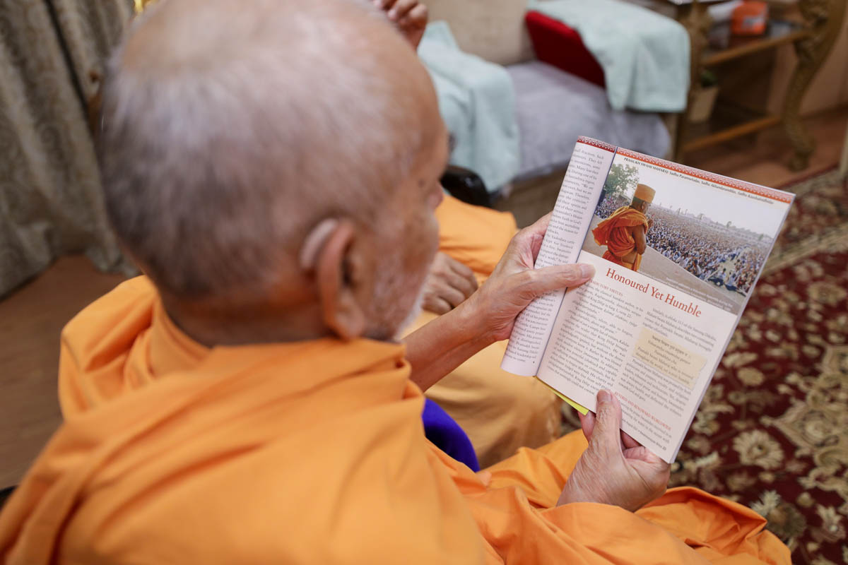 Swamishri reads the latest issue of 'Swaminarayan Bliss'