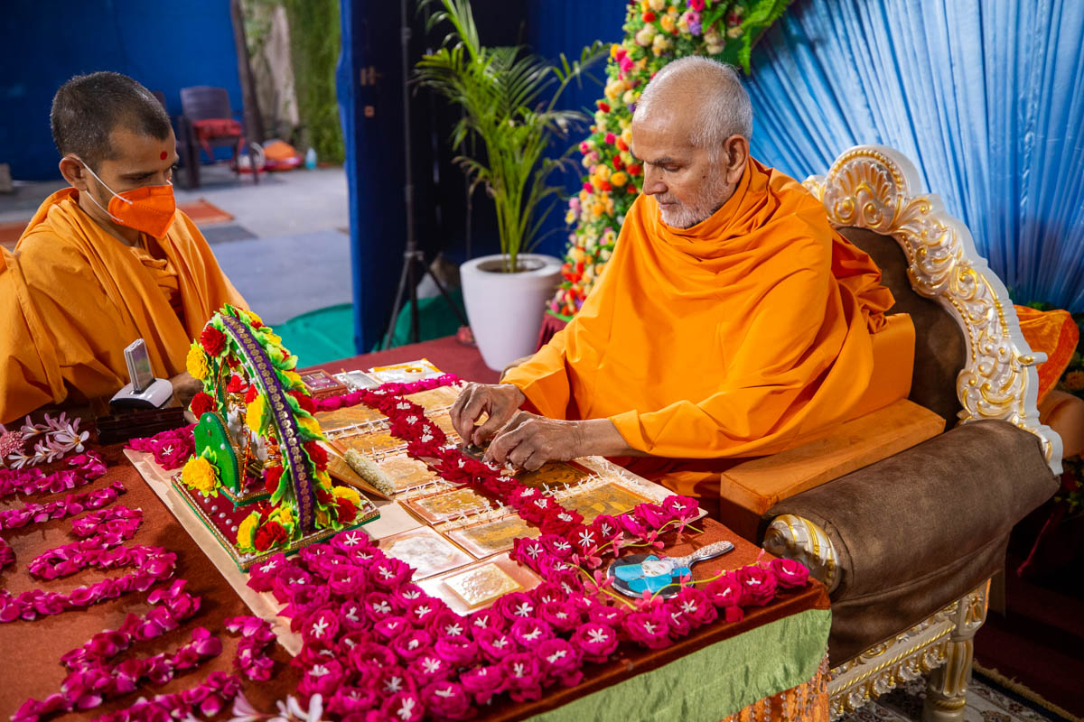 Param Pujya Mahant Swami Maharaj honors Brahmaswarup Pramukh Swami Maharaj with a garland in his daily puja