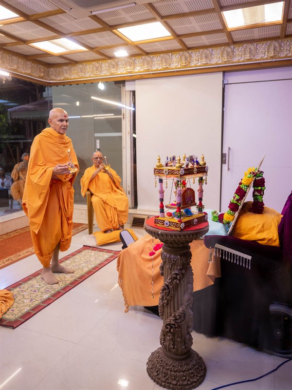 Swamishri and Pujya Swayamprakash Swami (Doctor Swami) perform the evening arti in the Pramukh Mandiram