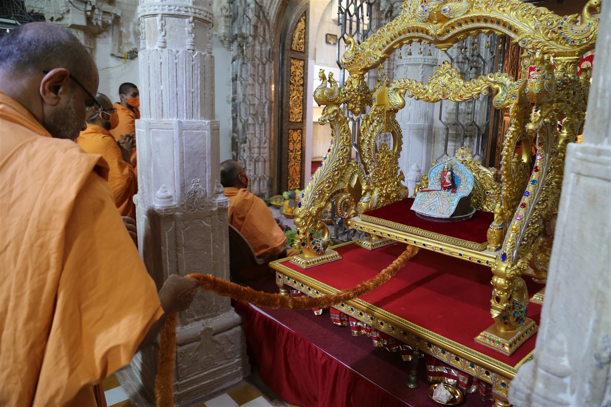 Gnaneshwar Swami swings Shri Harikrishna Maharaj on a hindolo in the mandir