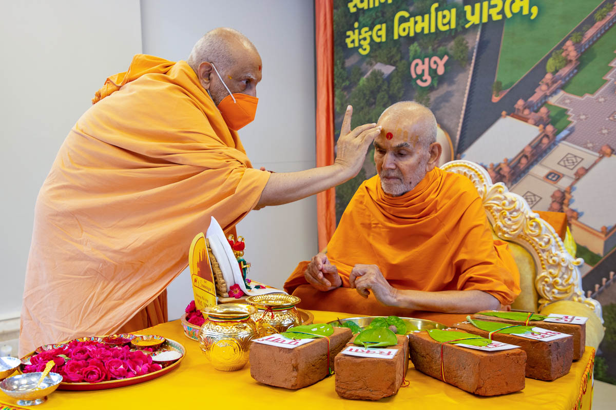 Atmaswarup Swami applies chandan archa on Swamishri's forehead