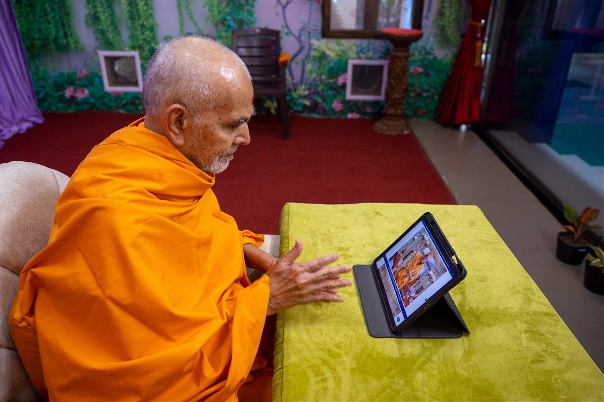 Swamishri views the pujan being performed by Pujya Ishwarcharan Swami