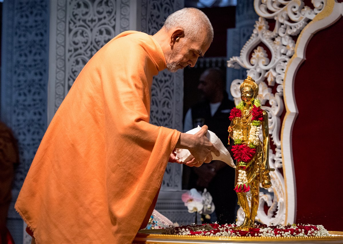 Pragat Brahmaswarup Mahant Swami Maharaj doing the abhishek of Shri Nilkanth Varni after the murti pratishtha of the new mandap on June 24, 2017