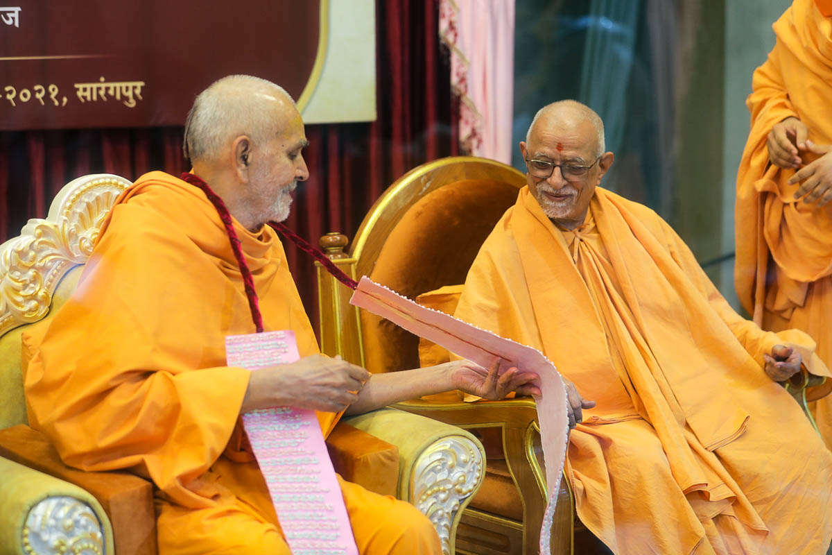 Swamishri and Pujya Swayamprakash Swami (Doctor Swami) observe a garland