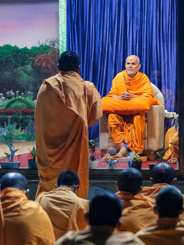 A sadhu presents a report to Swamishri