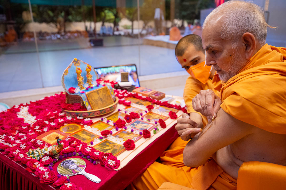 Param Pujya Mahant Swami Maharaj applies a tilak on his upper arm