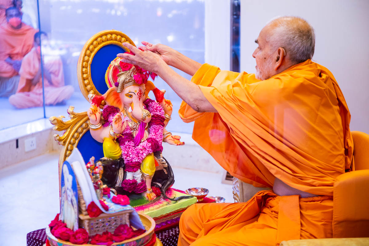 Swamishri showers flowers on Shri Ganeshji