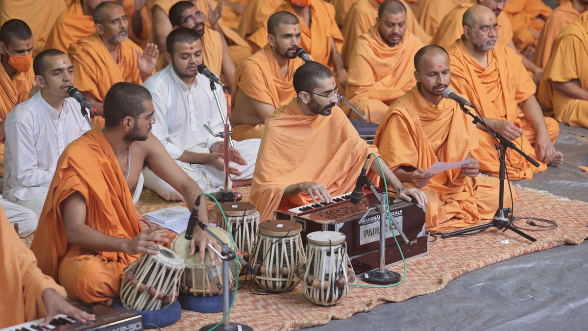 Sadhus sing kirtans at the beginning of the Swamishri's 88th Janma Jayanti celebration assembly in the evening
