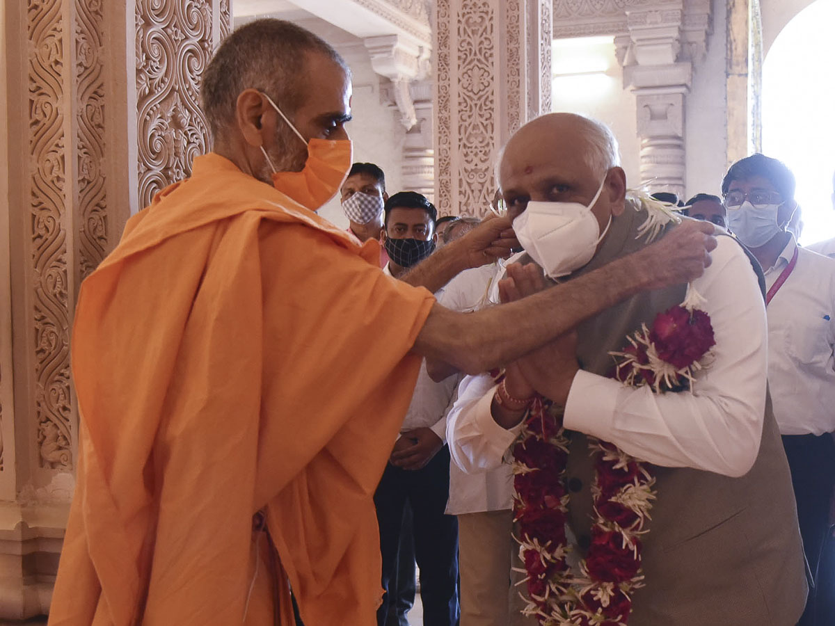 Anandswarup Swami honors Shri Bhupendrabhai Patel with a garland