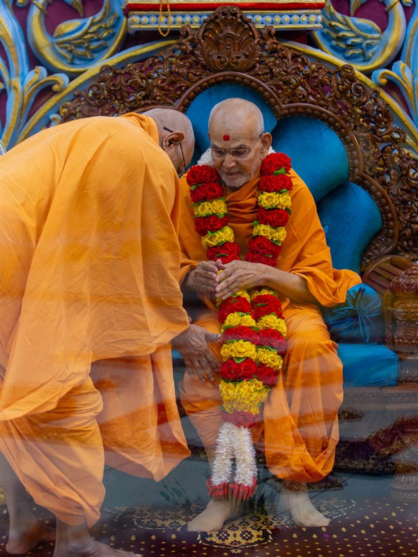 Pujya Swayamprakash Swami (Doctor Swami) honors Swamishri with a garland