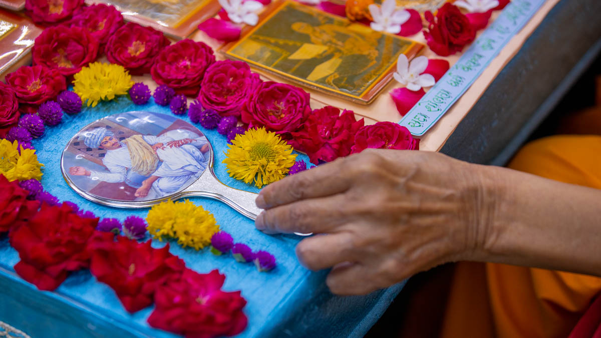 Swamishri adjusts the mirror in his daily puja