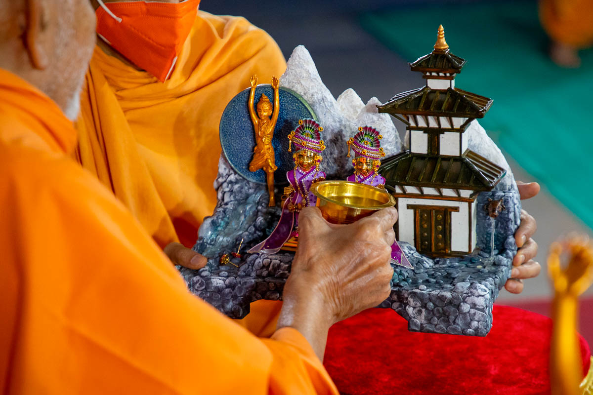 Swamishri offers water to Shri Harikrishna Maharaj and Shri Gunatitanand Swami