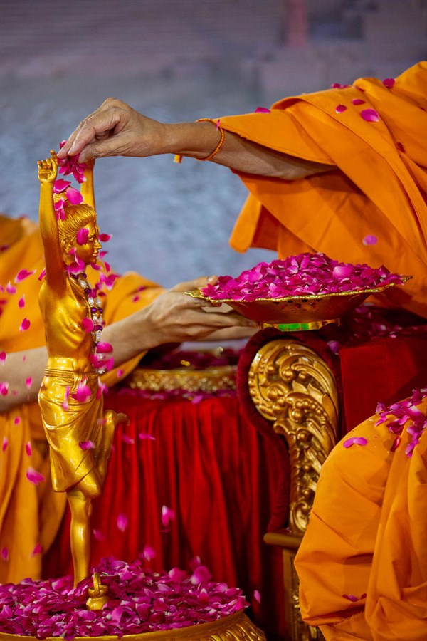 Swamishri showers flower petals on Shri Nilkanth Varni