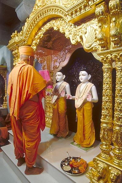  Holding a mirror before Shri Akshar Purushottam Maharaj 