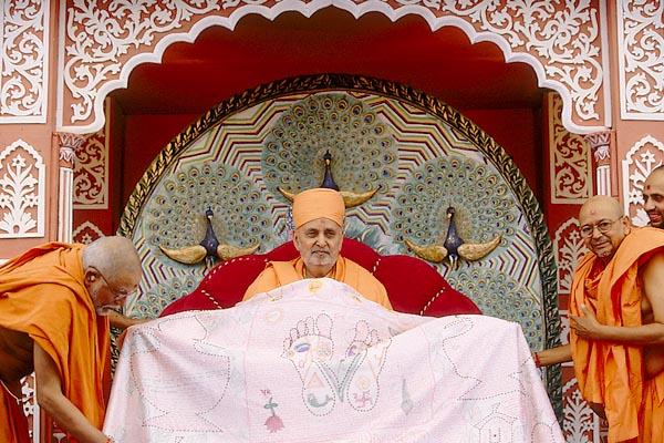    Senior sadhus garland and offer decorated shawls to honor Swamishri 