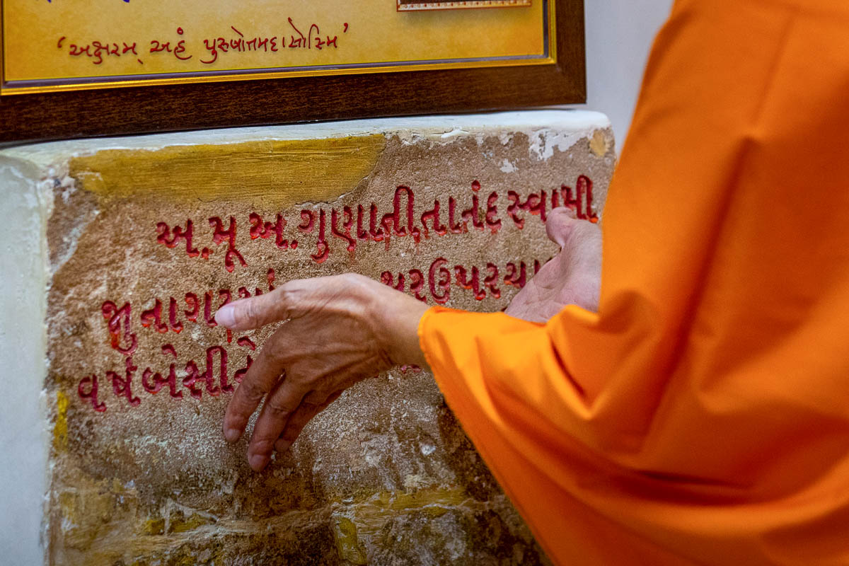 Swamishri engrossed in darshan of sacred stone