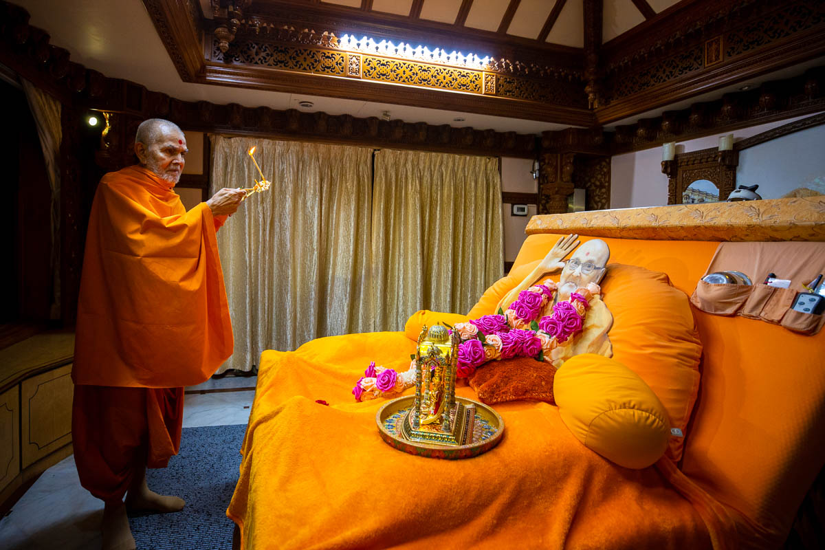 Swamishri performs the evening arti in the room of Brahmaswarup Pramukh Swami Maharaj