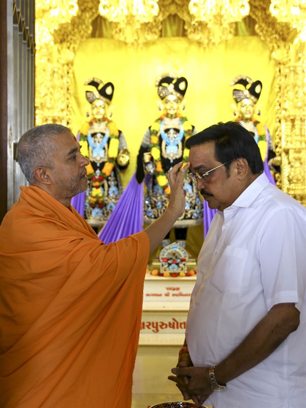 Brahmavihari Swami applies a chandlo to Shri C.R. Patil