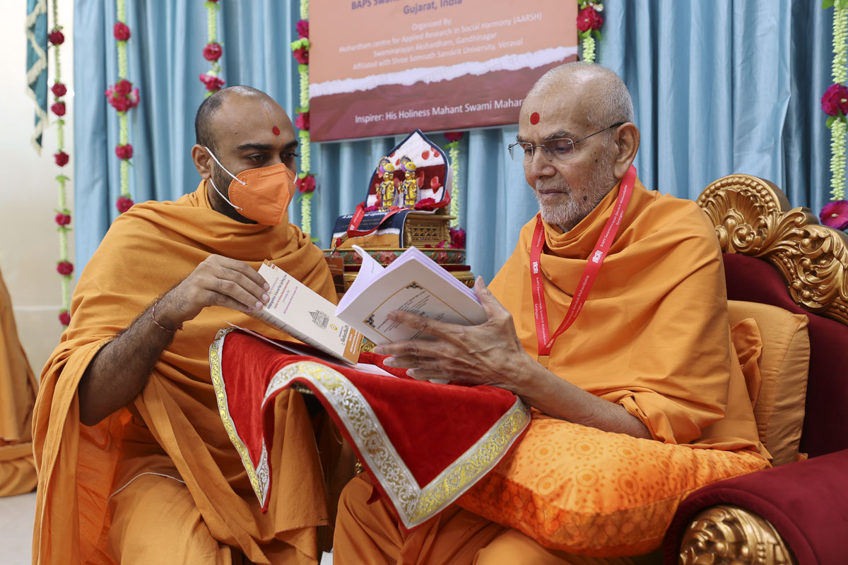 Swamishri sanctifies a book for the seminar